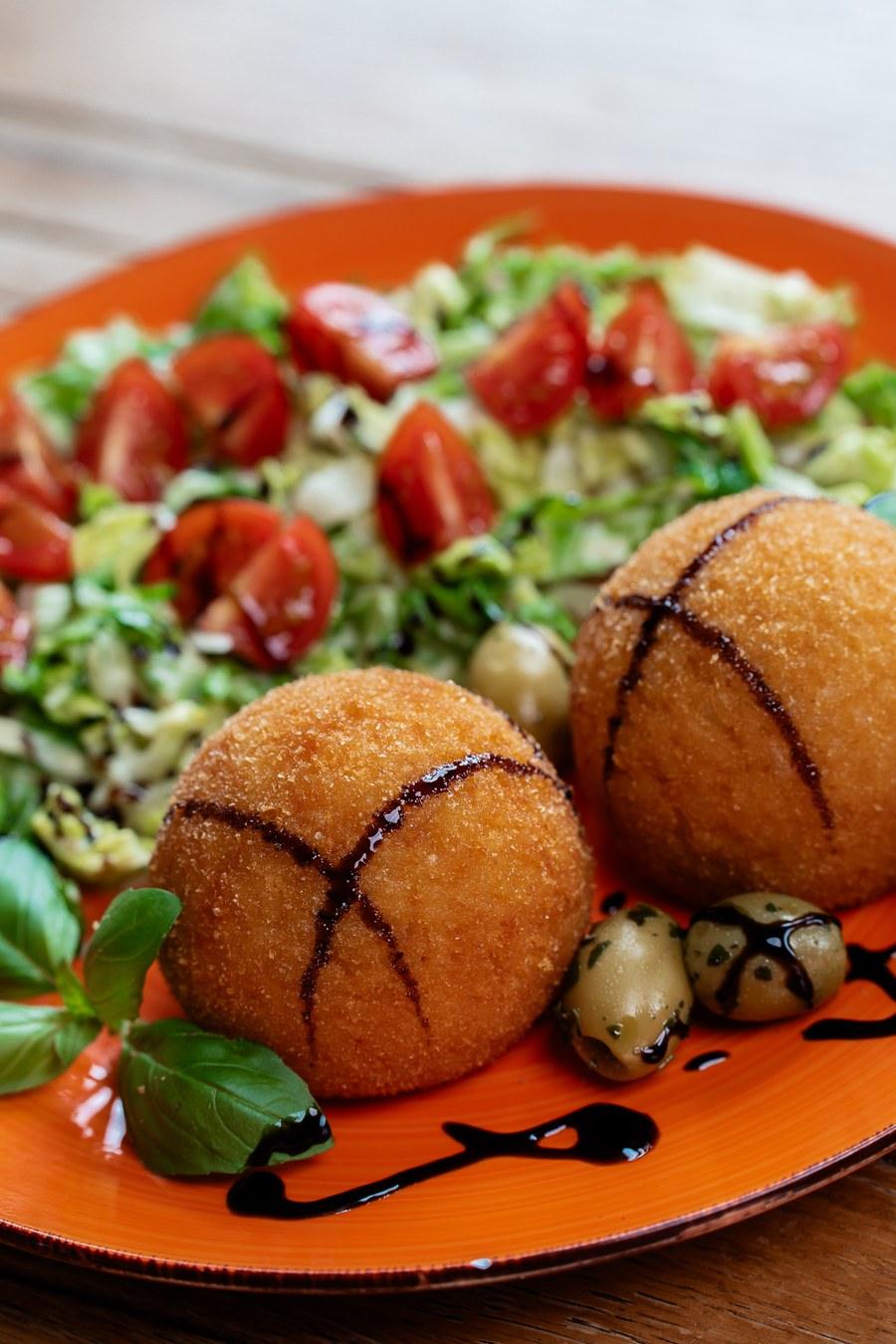 Arancini serviert mit Salat